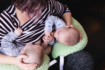 Image contains a mom breastfeeding her children