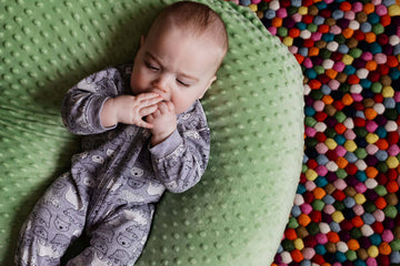 A baby wearing a grey colour printed onesies from OleOle