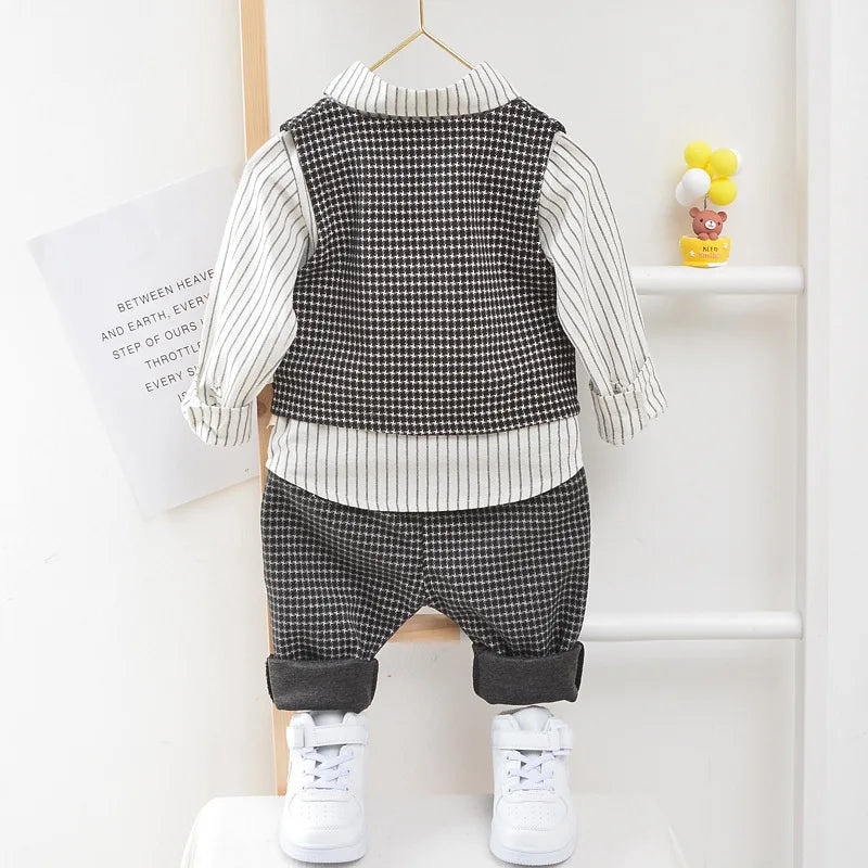 Children's outfit with checkered vest and pants on a hanger against a white background