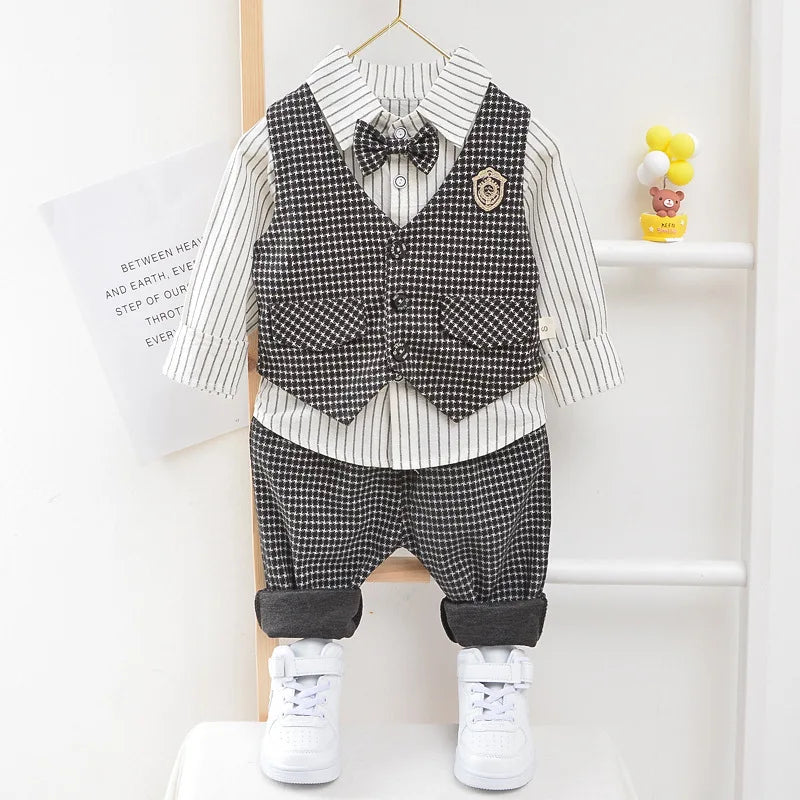 Children's outfit with checkered vest, pants, and shoes on a hanger against a white background.
