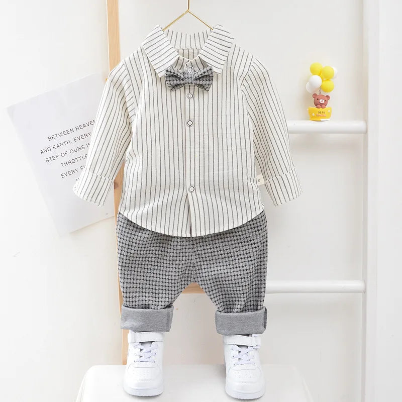 Children's outfit with striped shirt, bow tie, checkered pants, and white sneakers on a white background.