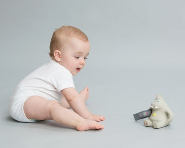 Image of Baby is playing with a Bear Toy - the image is used on OleOle Home Page for Baby Products & Accessories Collection - Adorable and Essential Items for Happy Babies