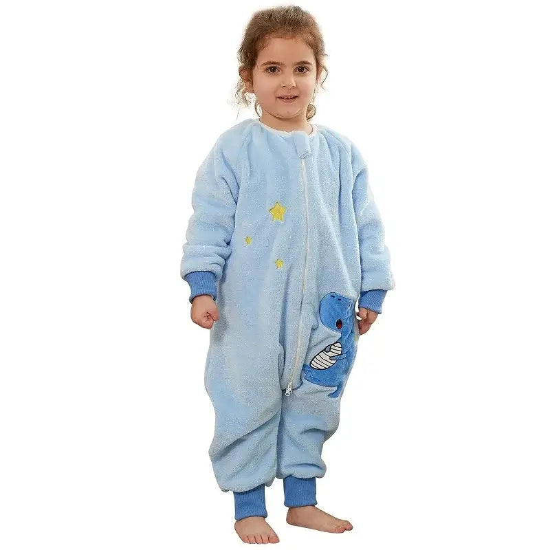 Smiling girl wearing a blue flannel warm onesie sleepsack with cartoon dinosaur design, perfect for cozy sleep.