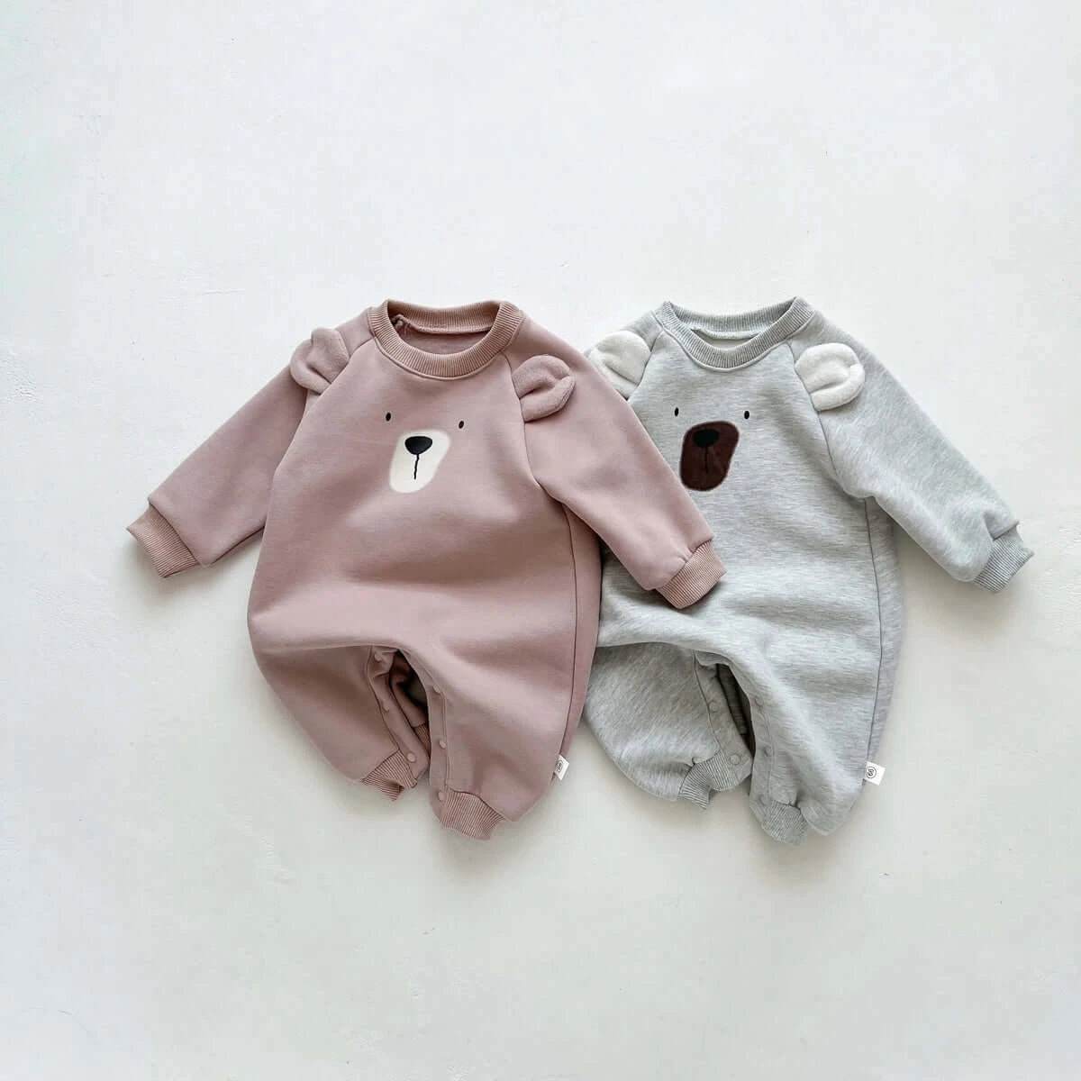Image of cosy fleece baby onesie with bear ears, perfect for winter comfort. Shop now at OleOle.