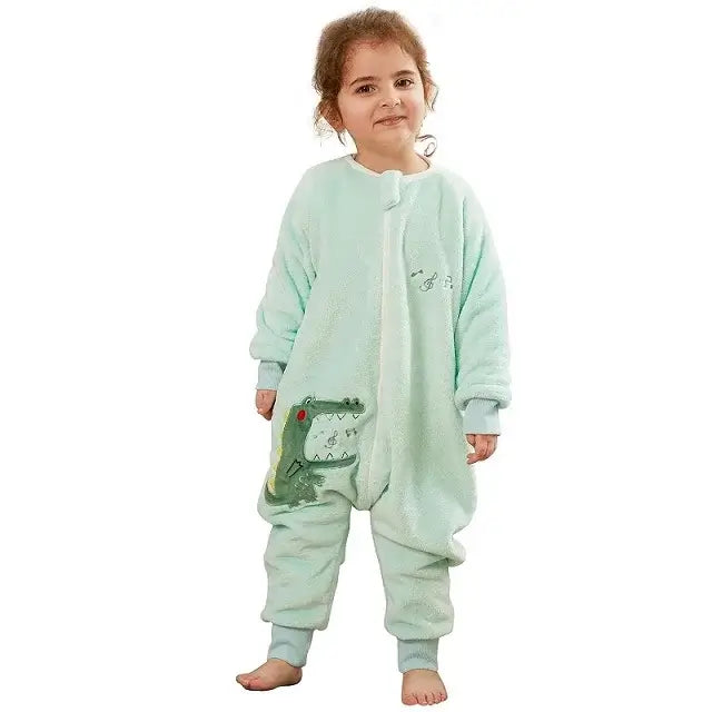 Cute girl wearing a mint green kids flannel onesie sleepsack with cartoon frog design.