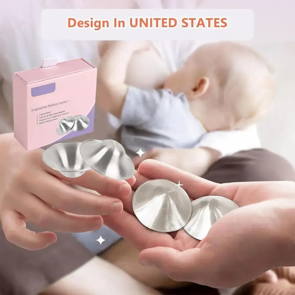 Silver breast pads held by hands with a baby in the background and a pink packaging box.