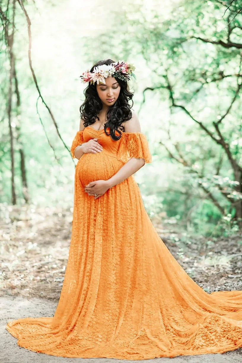 Pregnant woman in an orange dress standing in a forest