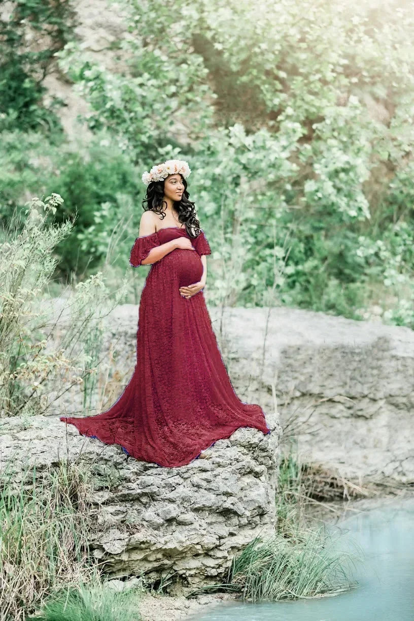 Woman in a burgundy dress standing on a rock with a natural background