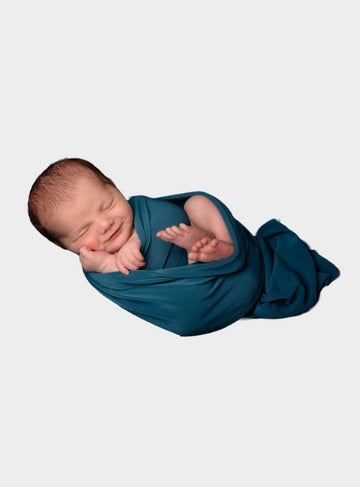 Image of a Smiley Newborn Baby in Deep Blue Swaddle Blanket - it is used at OleOle Newborn Collection Page